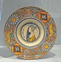 Italian Renaissance maiolica dish with a painted profile portrait of a woman, framed by an ochre rim of animals and ornament.