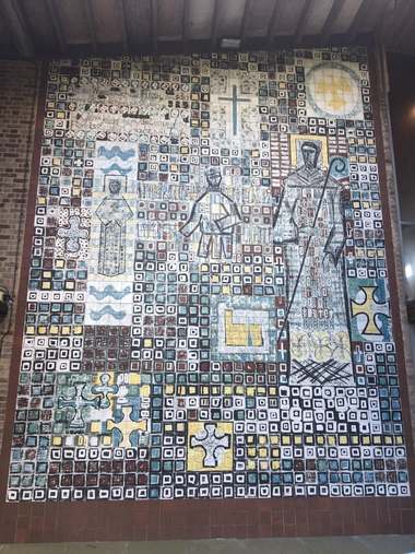 Large mid-century ceramic tile mural of a monk with a crozier, a crowned figure and crosses, set in a grid of hand-painted squares