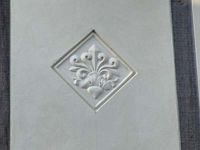 Close-up of a diamond-shaped decorative plaster panel between dark oak timbers on the Old Grammar School